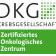 DKG Krebsgesellschaft Zertifiziertes Onkologisches Zentrum: Zusehen ist das Logo der DKG, die eine Hälfte ist weiß mit schwarzer Schrift, die andere Hälfte (ab Zertifiziertes Onkologisches Zentrum) ist grün mit weißer Schrift. 